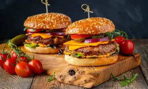 Dwa soczyste burgery z wołowiny, idealne na grilla. Idealne jakie mięso na burgera? To właśnie takie! Z serem, warzywami i piklami.
