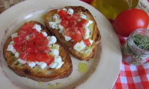 Bruschetta z pomidorami i mozzarellą: chrupiące grzanki z soczystymi pomidorami i kremową mozzarellą, posypane ziołami. Idealny przepis na szybką przekąskę.
