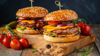 Dwa soczyste burgery z wołowiny, idealne na grilla. Idealne jakie mięso na burgera? To właśnie takie! Z serem, warzywami i piklami.