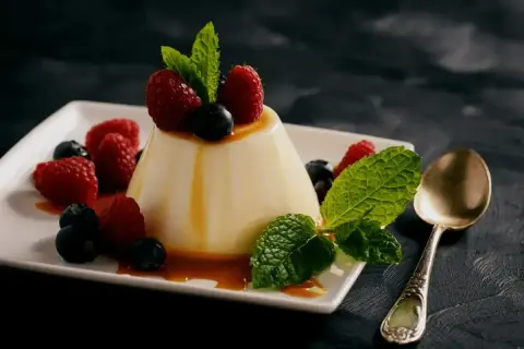Panna cotta z malinami i borówkami, polana karmelem. Idealny deser, który zachwyci każdego. Oto panna cotta oryginalny przepis.