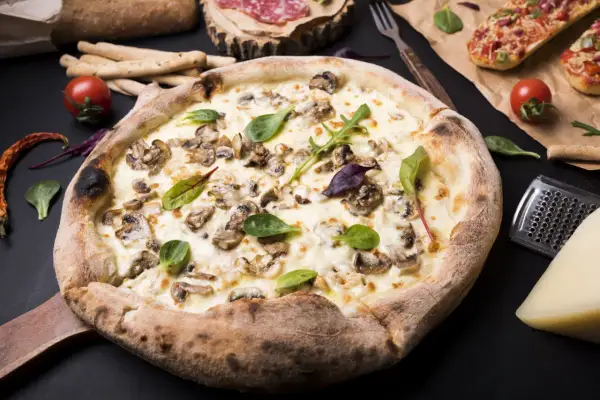Pizza z pieczarkami idealna jak z pizzerii. Jakich pieczarek użyć, by nie puściły wody?